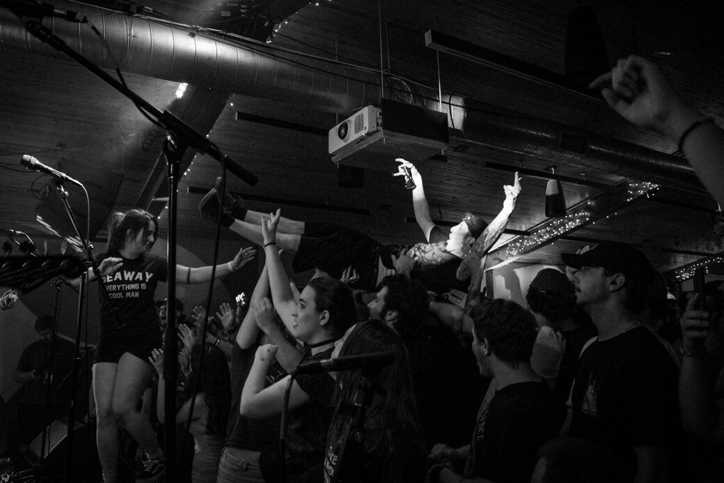 A black and white photo of rowdy Arm's Length fans at Broom Factory in Kingston.