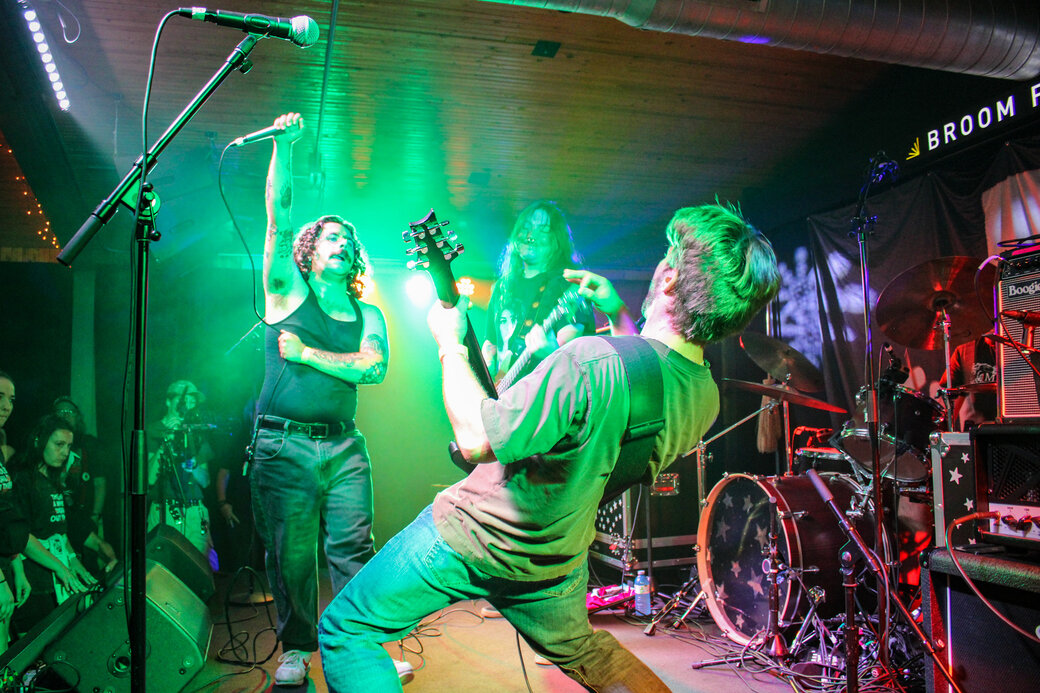 Band members of Mile End revel under coloured lights on stage at Broom Factory in Kingston.
